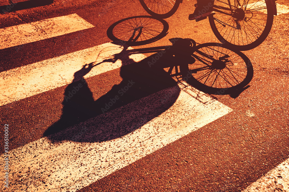 Shadow of cyclist on pedestrian zebra crossing