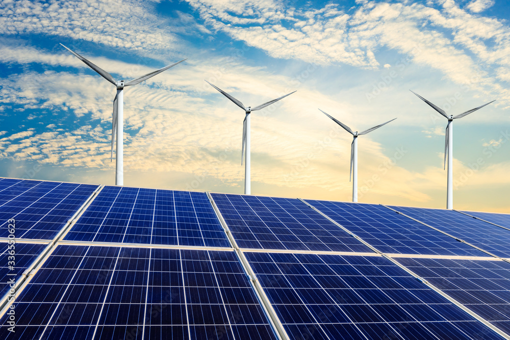 Solar panels with wind turbines in the setting sun,green energy.