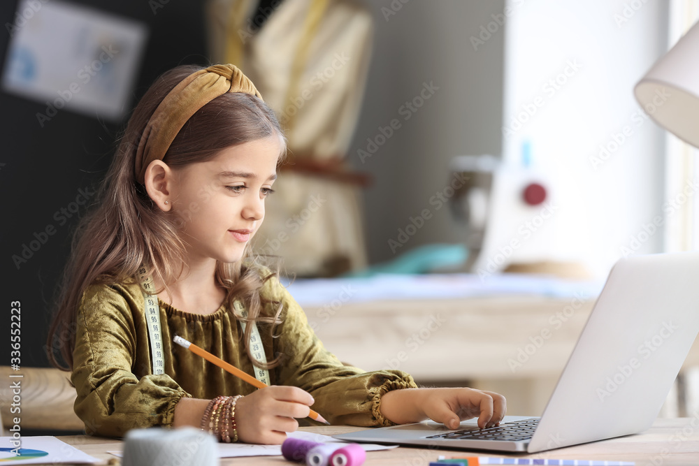 Cute little dressmaker working in atelier