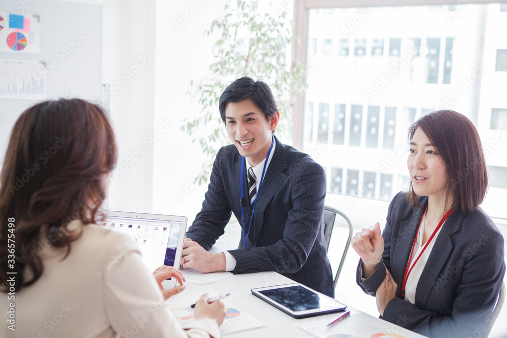 来社した営業マンの話を聞く女性