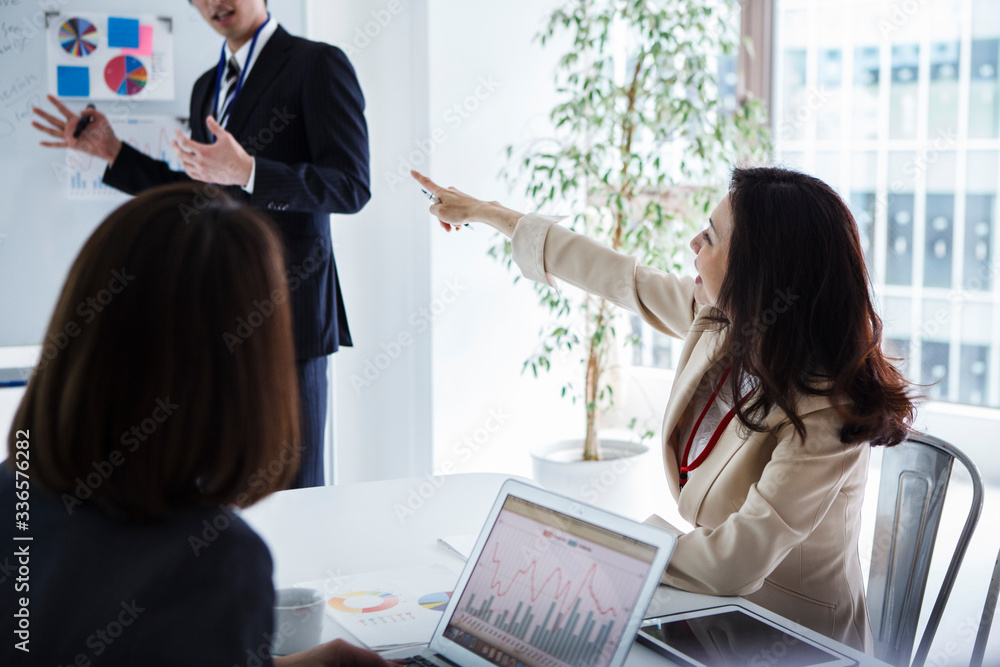 ミーティングで指示を出す女性幹部