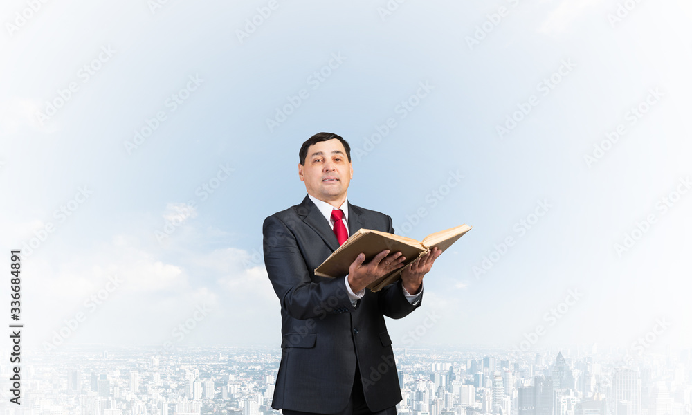 Serious businessman holding open old book