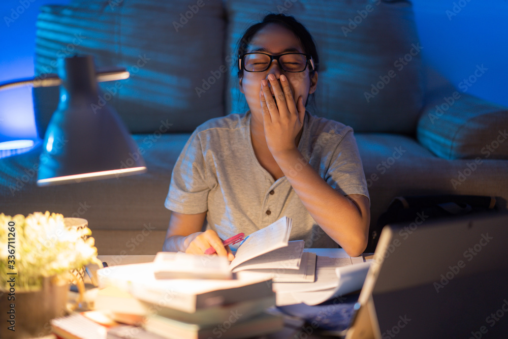 Asian women tired from working at home She felt sleepy yawning.