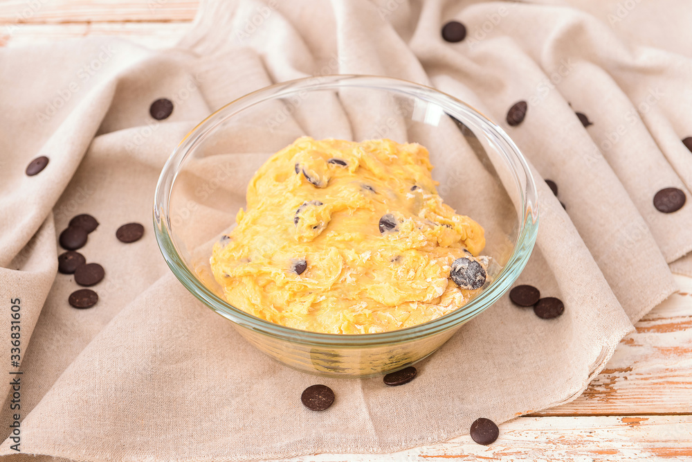 Bowl with sweet dough on table