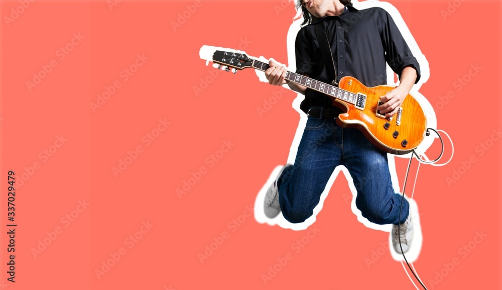 Male guitarist playing music and jump