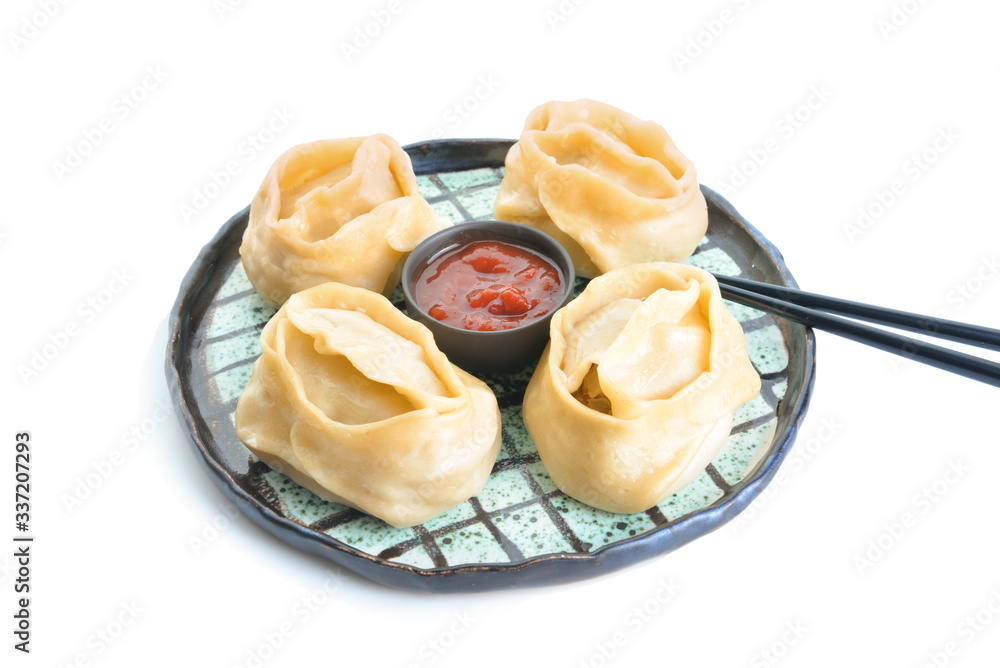 Plate with oriental dumplings and sauce on white background