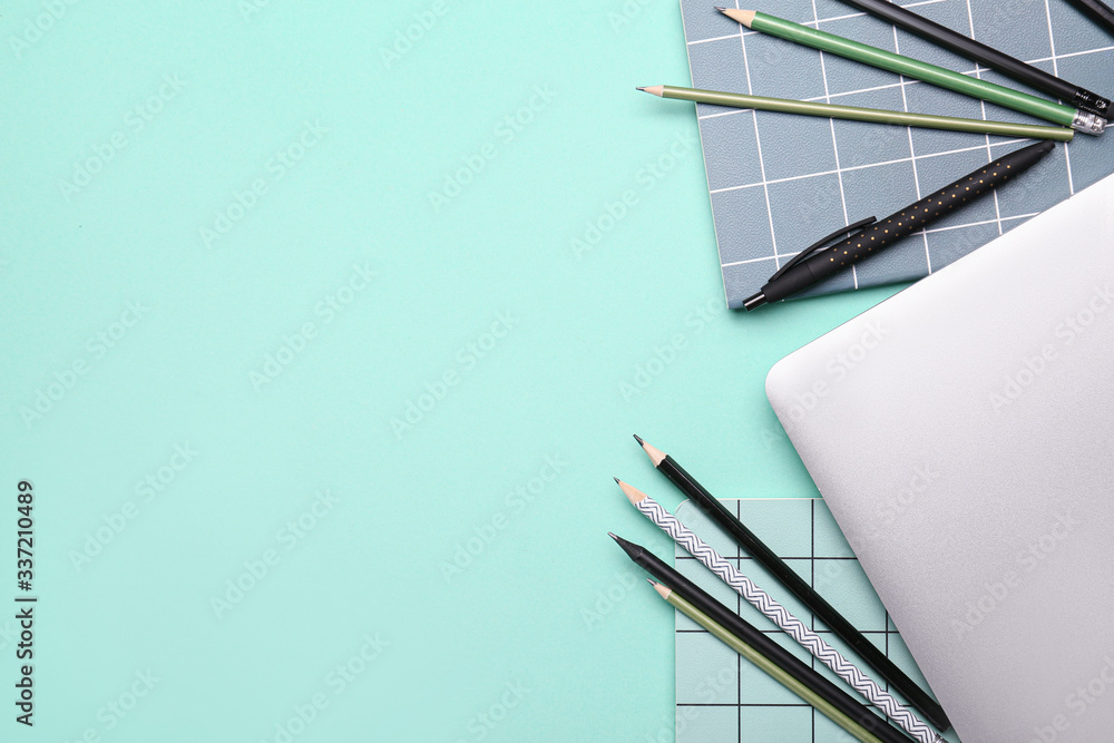 School supplies with laptop on color background