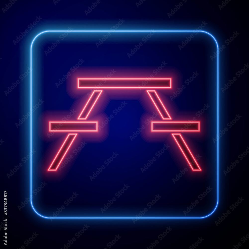 Glowing neon Picnic table with benches on either side of the table icon isolated on blue background.