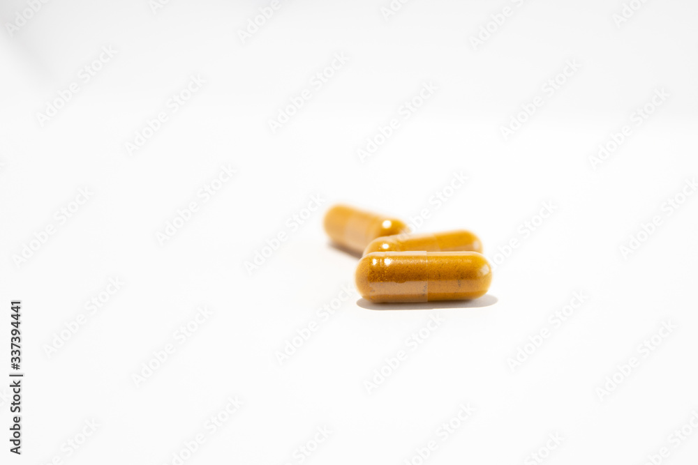 Three yellow pills (gel capsules with curcuma)