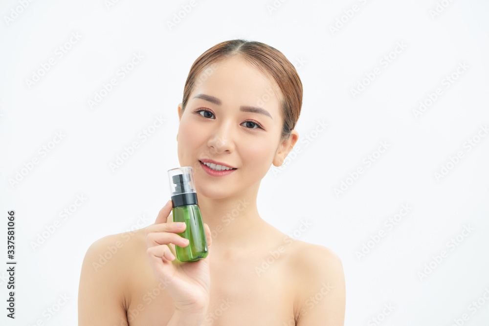 Portrait of young beautiful Asian woman showing cosmetic product green bottle on hand.