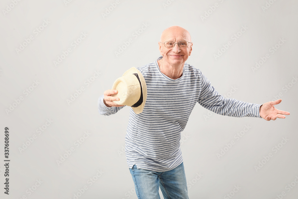 Portrait of happy elderly man on grey background