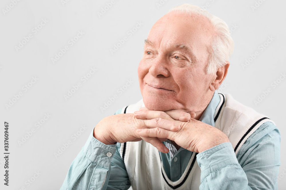 Portrait of elderly man on grey background