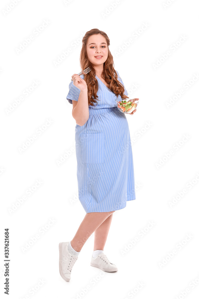 Beautiful pregnant woman with healthy salad on white background