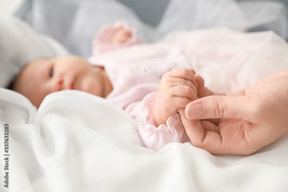 Cute little baby holding mothers hand, closeup