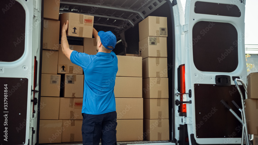 Courier Takes out Cardboard Box Package from Delivery Van Full of Parcels, Delivering Postal Parcel.