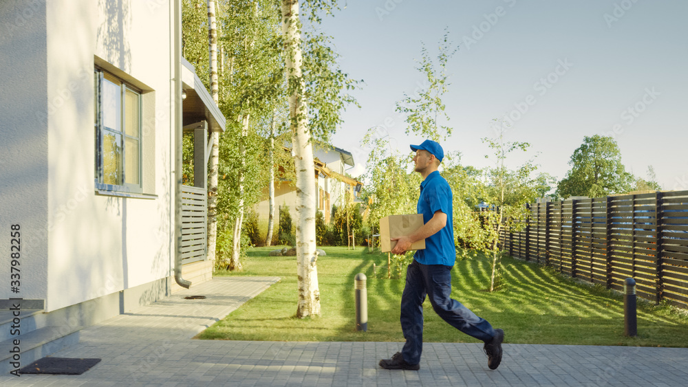 Delivery Man Holding Card Board Package Enters Through the Gates and Walks to the House and Knocks. 