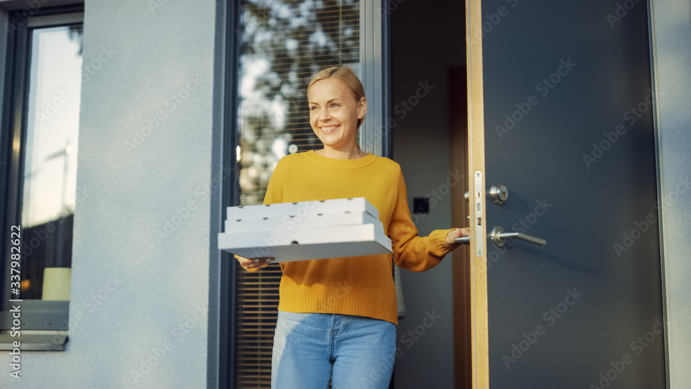 Beautiful Young Smiling Woman Opens Doors of Her House and Holds Cardboard Boxes Full of Tasty Steam