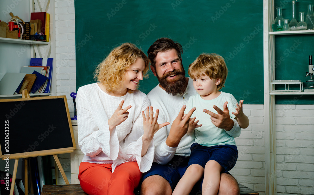 有趣的小孩和家人在黑板背景上玩得很开心。母亲和父亲和儿子在一起