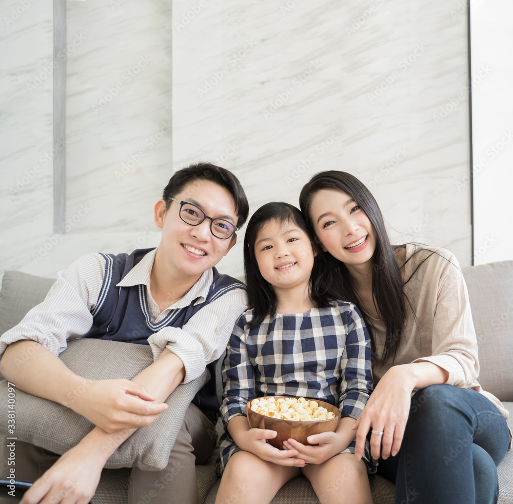 Portrait of happy Asian family spending time together on sofa in living room at home. family watchin