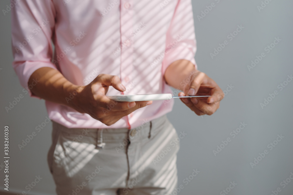 Man holding mobile phone with Payment Detail page display and credit card, online shopping concepts