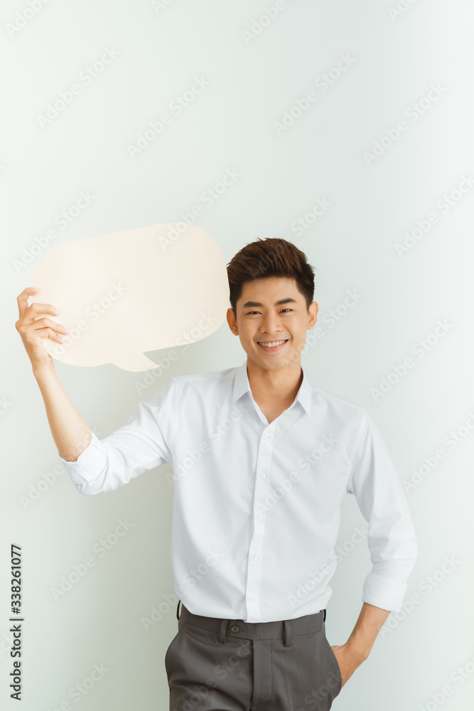 Young Asian man holding blank speech bubble on white background