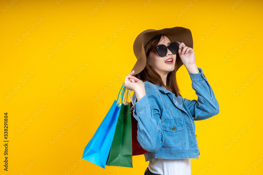 Portrait of Asian woman nice attractive wearing sun glasses carrying new shopping bag touching sun g