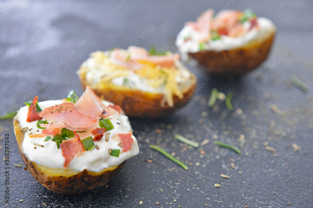 Tasty baked potato with sour cream on dark background