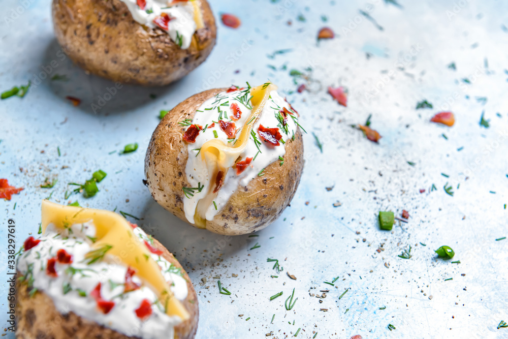 Tasty baked potato with sour cream on color background