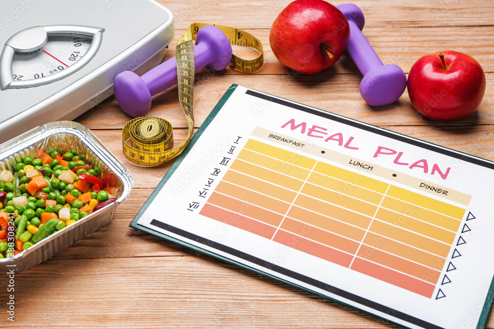 Meal plan with healthy products, measuring tape, scales and dumbbells on wooden background