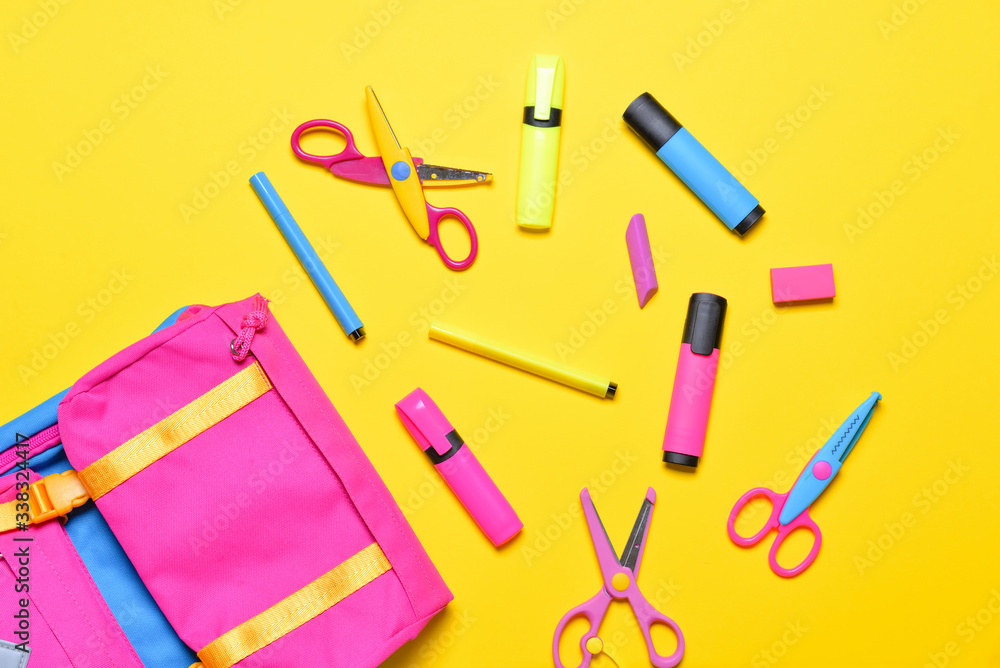 School backpack and stationery on color background