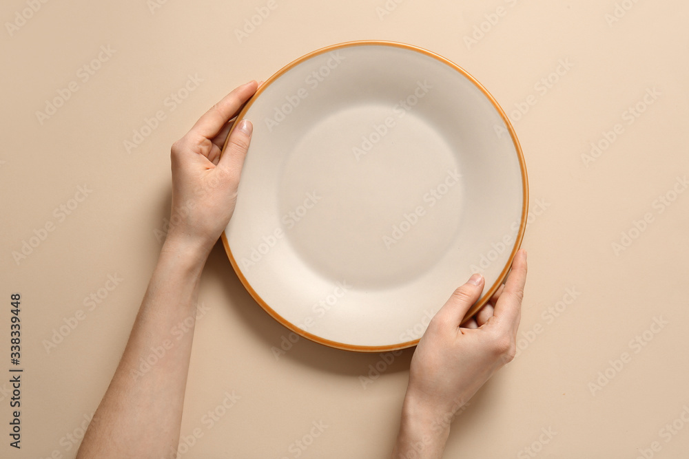 Woman at table with clean plate, top view