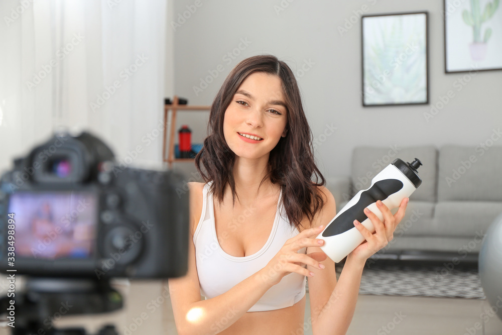 Young female blogger recording video about sport at home