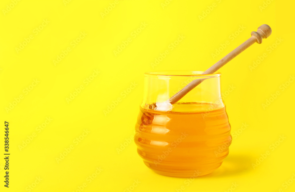 Jar of sweet honey on color background