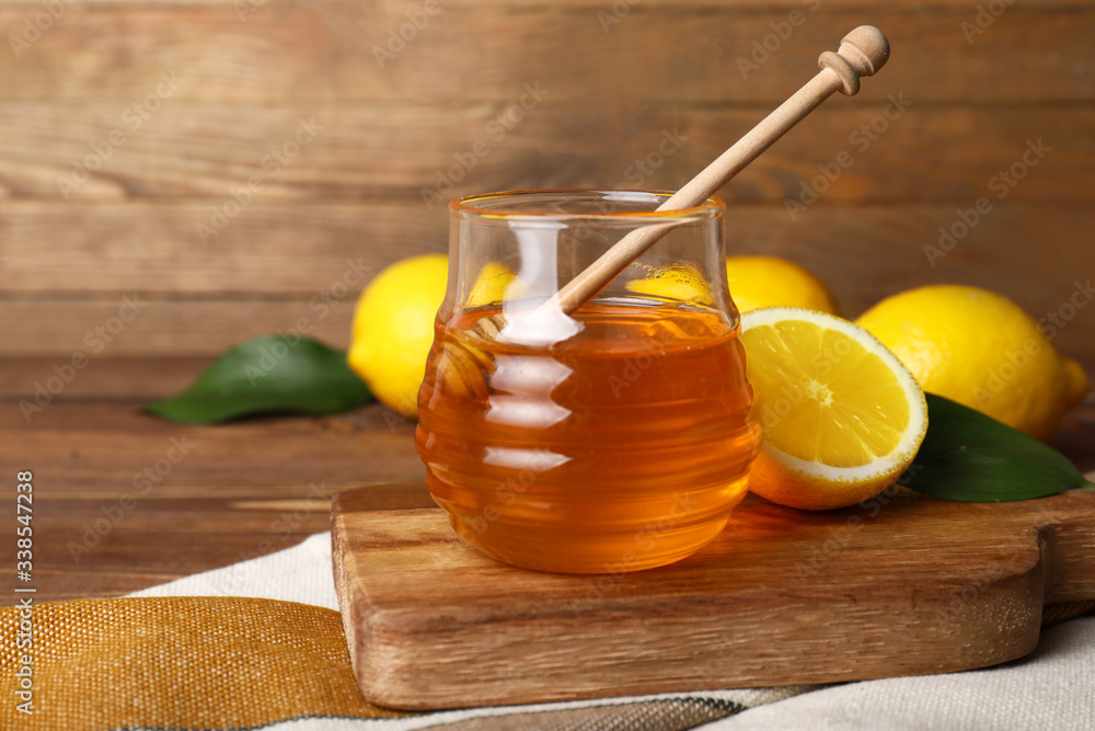 Jar of sweet honey on wooden background