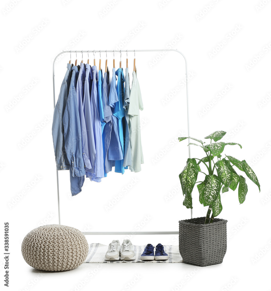 Rack with clothes and shoes on white background