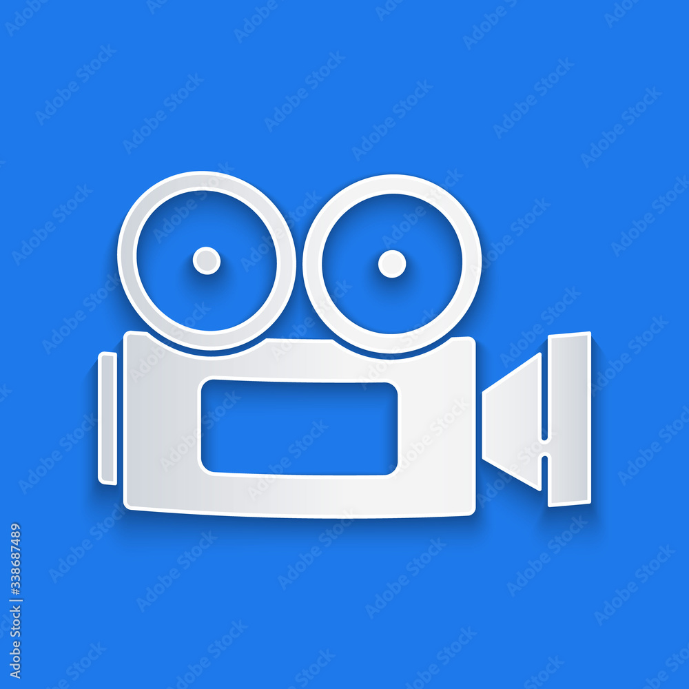 Paper cut Cinema camera icon isolated on blue background. Video camera. Movie sign. Film projector. 