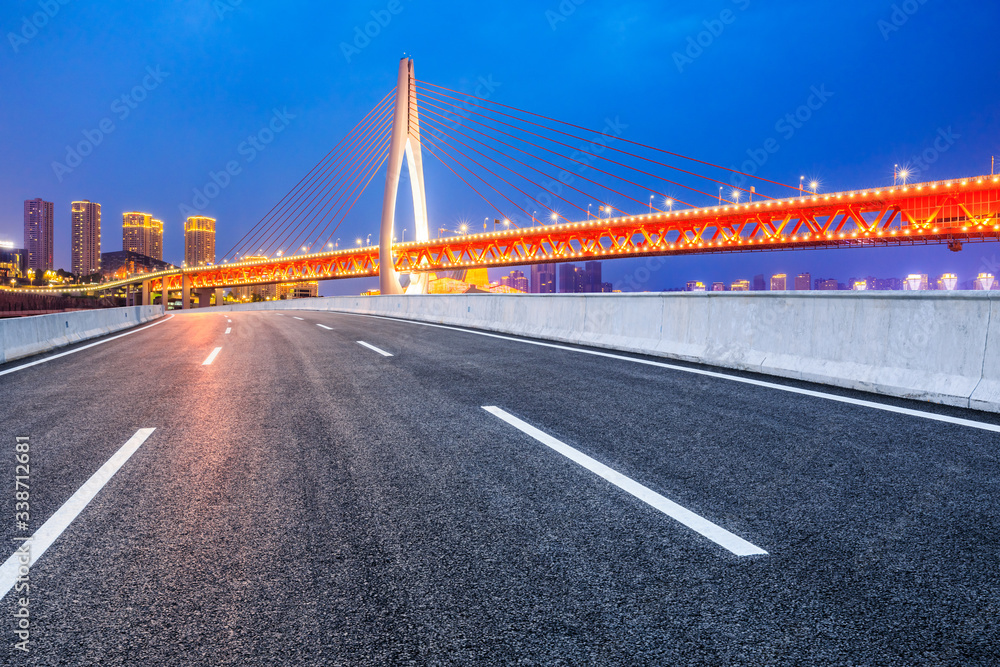 Empty asphalt road and city skyline with buildings at night in Chongqing,China.