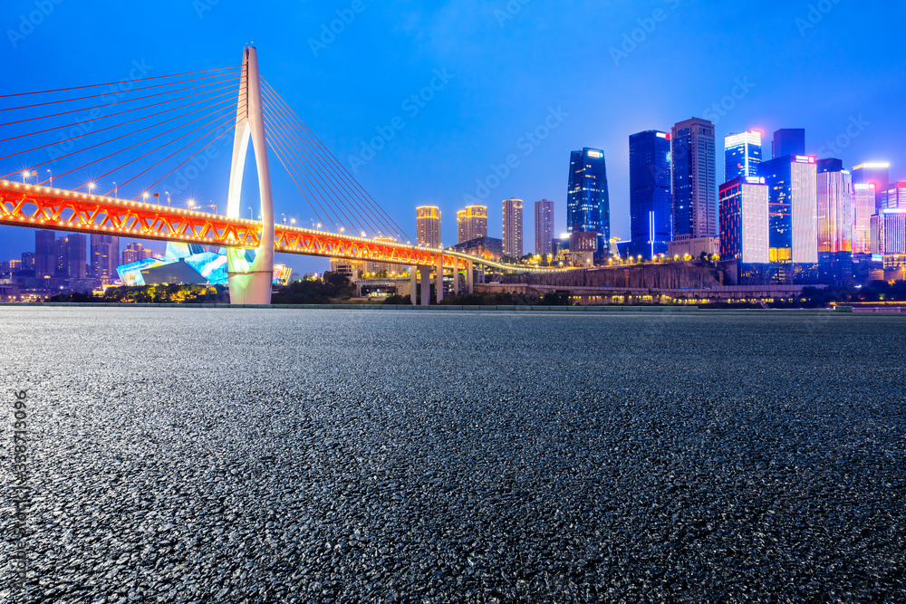 Empty asphalt road and city skyline with buildings at night in Chongqing,China.