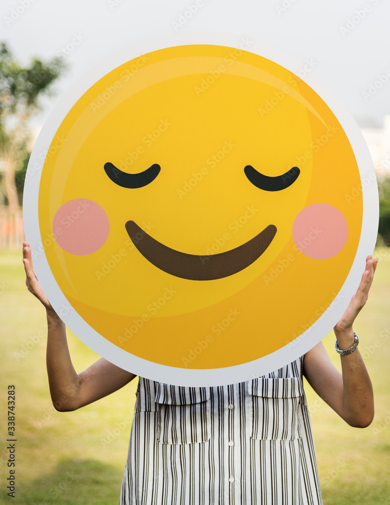 Woman holding a smiley face icon