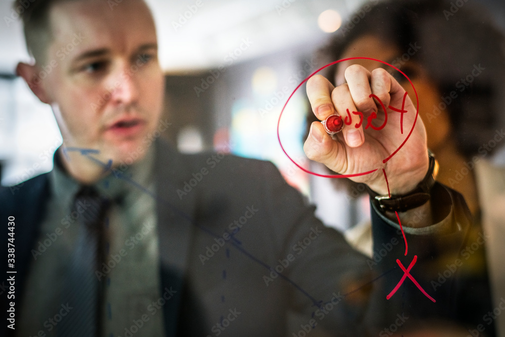 Businesspeople planning on a glass wall