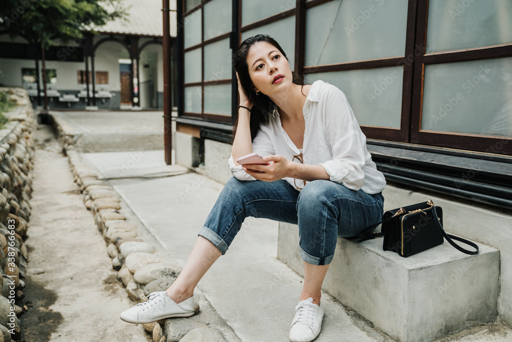 旅游亚洲中国女孩用手机享受暑假旅游。年轻女子来访