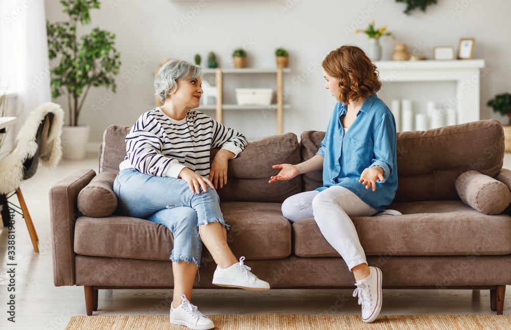 Mother and daughter speaking on couch.