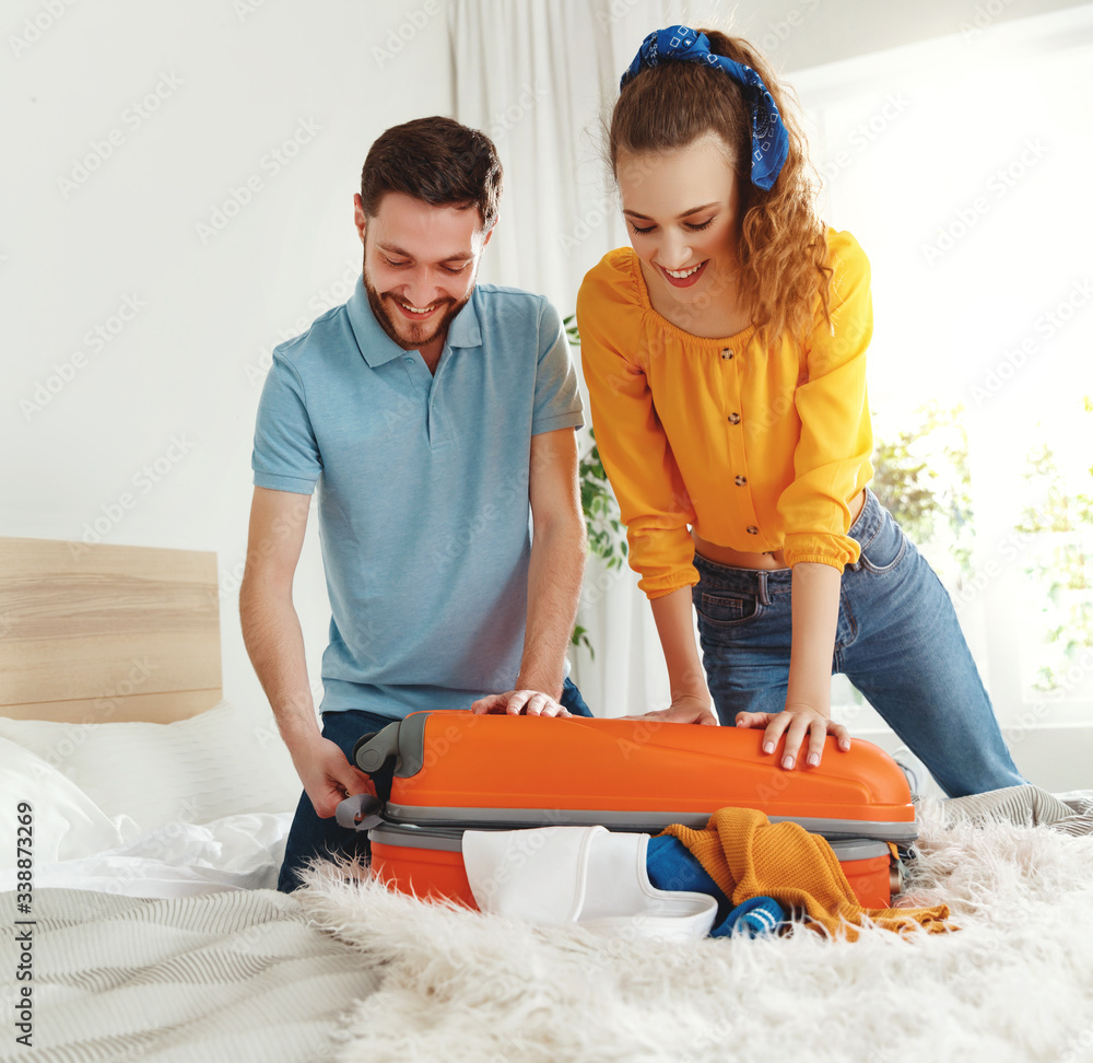 Happy couple packing luggage for vacation.