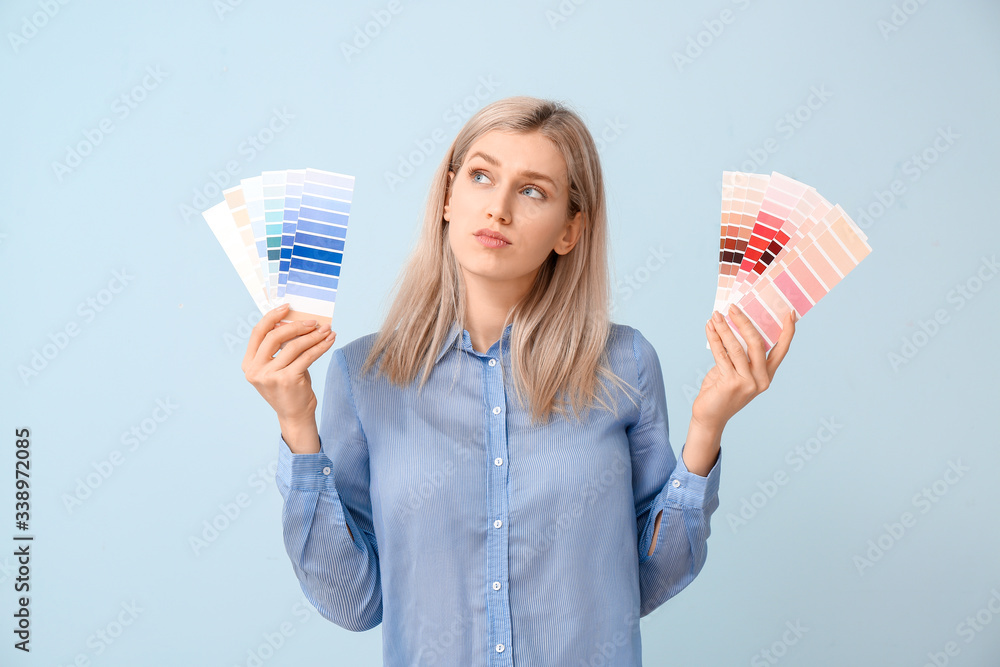 Young woman with paint palette on color background