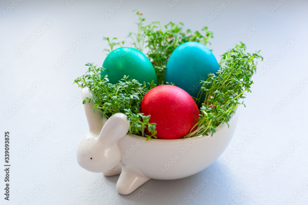 Painted Easter eggs in a bowl with cress