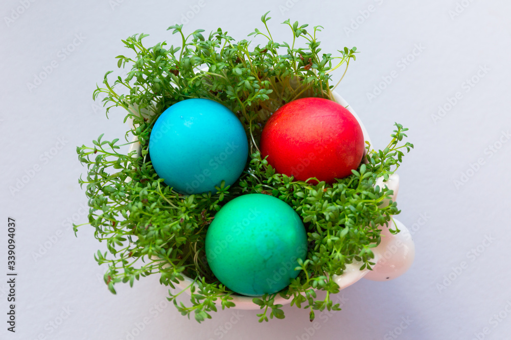 Painted Easter eggs in a bowl with cress