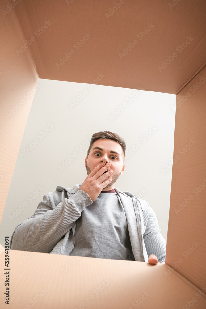 Shocked man with open box, view from inside