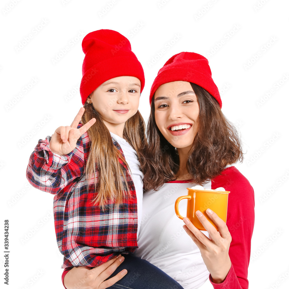 Woman and her little daughter with tasty cocoa drink on white background