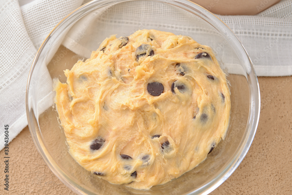 Bowl with sweet dough on table, closeup