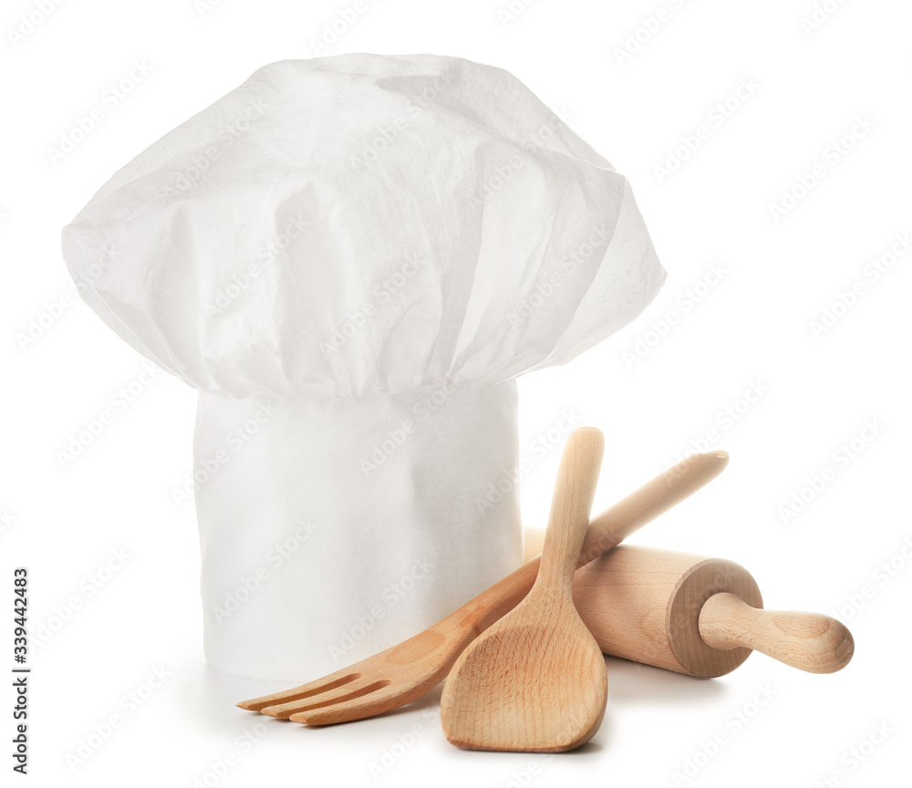 Chefs hat and kitchenware on white background